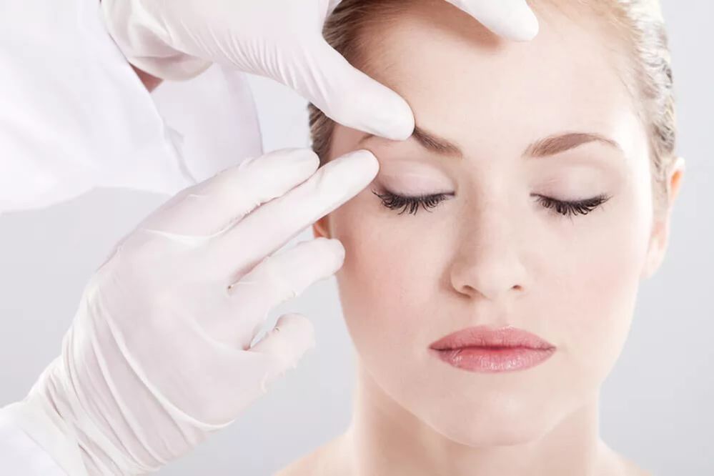 O cosmetologista examina a pele ao redor dos olhos